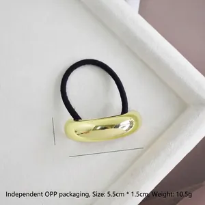 Detail view of large U-shaped golden metal hair ring with size specs 5.5cm x 1.5cm