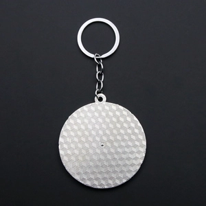 Detailed macro view of the textured metallic back on the daisy mood keychain charm