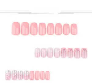 Detailed view of pink press-on nails featuring French tips, stars, and ombre patterns