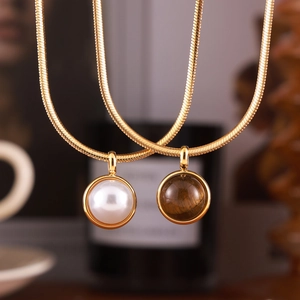 Vintage gold snake chain necklaces featuring pearl and tiger eye stone pendants