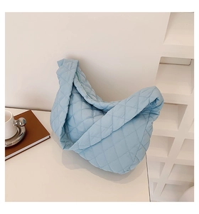 Detail shot of light blue quilted nylon tote bag with soft padded puffer texture