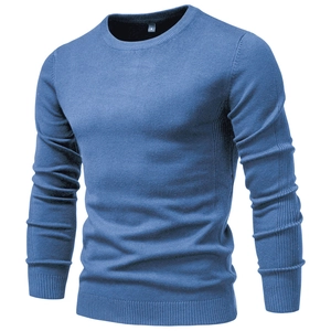 Detail of blue crewneck knit sweater showing neckline tag and fine fabric texture