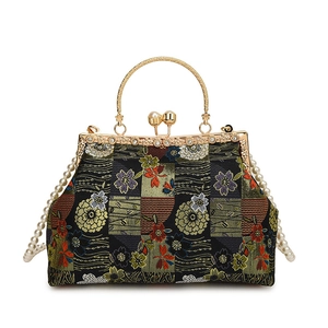 Close-up of floral embroidery on evening bag with gold metal frame and pearl strap