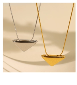 Detail of gold and silver minimalist triangle pendants on sleek snake chains