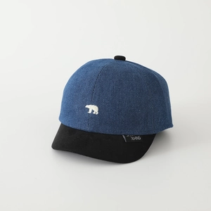 Close-up of embroidered white polar bear on blue denim baseball cap with black brim
