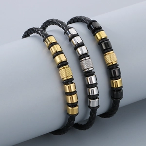Detailed view of woven leather bracelets with gold, silver, and black metal beads set