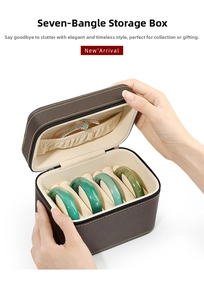 Detail of a brown leather jewelry box showing 7 slots for bracelets and a zipper closure