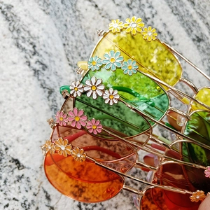 Detail of colorful daisy flower sunglasses for kids with vibrant metal frames and tinted lenses