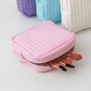 Quilted leather storage pouch in macaron colors showing makeup brush capacity