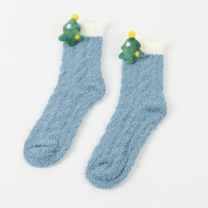 Detail von weichen blauen Plüschsocken mit weißen Bündchen und süßem 3D Weihnachtsbaum