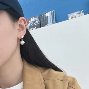 Orecchini a sfera in argento sterling 925 con texture martellata su una modella di moda