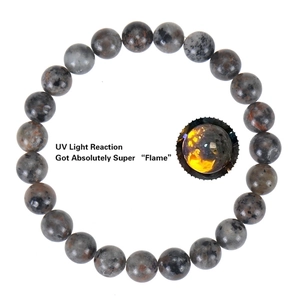Natural Yooperlite bead bracelet with vibrant flame pattern under UV light reaction