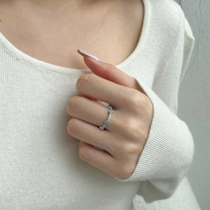 Close-up of S925 silver ring featuring blue heart zircon stones worn on finger