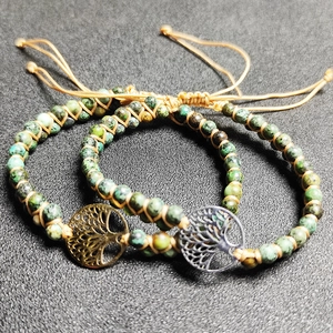 Macro detail of braided African turquoise stone beads and Tree of Life metal charm