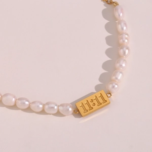 Detailed macro view of freshwater pearl bracelet featuring an 11:11 gold pendant charm