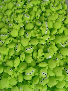 Macro detail of bulk green silicone Alien cable protectors in factory storage