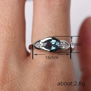Elegant marquise cut blue gemstone ring with side diamonds on a silver band