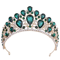 Close-up of golden vintage bridal crown with green gems and sparkling crystals