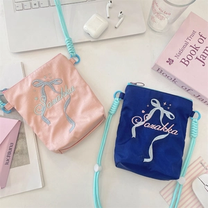 Vue détaillée du motif de nœud brodé délicat sur les sacs à bandoulière en toile