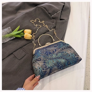 Detailed view of teal peacock feather pattern vintage handbag with metal chain and handle