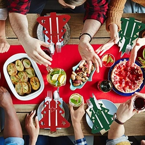 Porte-couverts de Noël en feutre rouge et vert sur une table de fête en bois massif