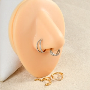Detailed view of silver and gold triple-layered zircon septum hoops on silicone nose model