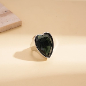Détail d'une bague coeur en argent avec une grande pierre zircon vert émeraude