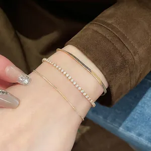 Set of three gold plated zircon square snake chain bracelets on a model's wrist