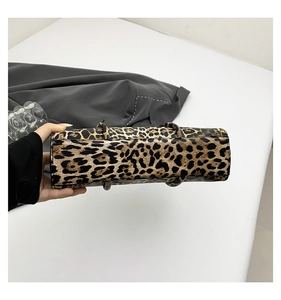 Macro view of the rectangular base and stitching detail of the leopard print baguette bag