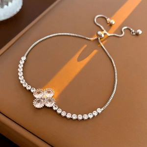 Detail of adjustable silver bracelet with zircon flower and sliding clasp on leather