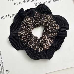 Detail of double-layer leopard print scrunchie with black pleated edges and fabric texture