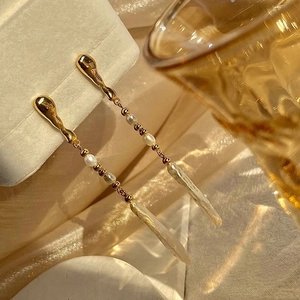 Close-up of long gold baroque pearl fringe earrings displayed on a jewelry box