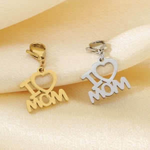 Close-up of heart-shaped MOM pendant charms in gold and silver steel on satin