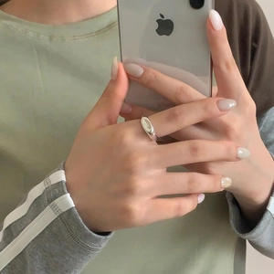 Close-up of minimalist sterling silver eight-pointed star open ring worn on finger