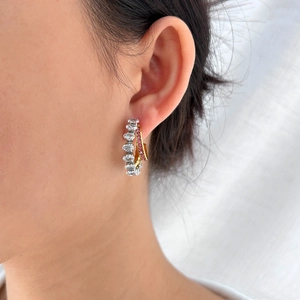Detail of double-layer C-shaped earrings with pink gems and white pavé zircons