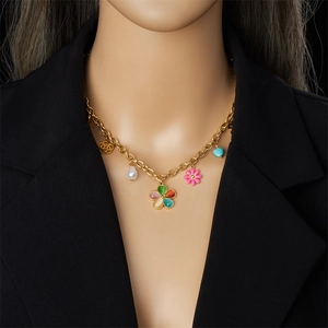 Golden multi-pendant chain necklace with colorful resin flowers and pearls on black suit