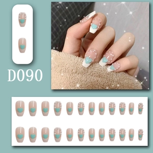 Detail of D090 nude fake nails with mint green hearts and pearl accents for manicure