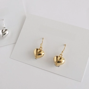 Detailed view of 925 silver heart dangle earrings in gold and silver finish on display