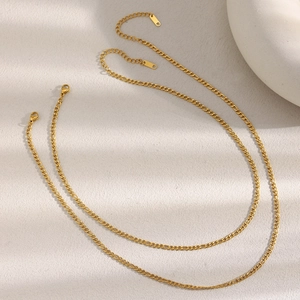Detail of two 18K gold plated stainless steel Figaro chains with secure lobster clasps
