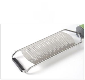 Macro detail of stainless steel zester blade with ergonomic green non-slip handle
