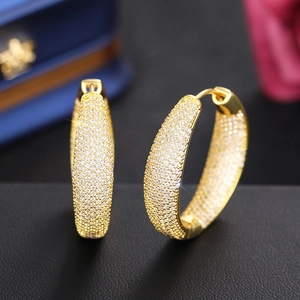 Macro view showing the pave setting of white zircons on golden hoop earrings