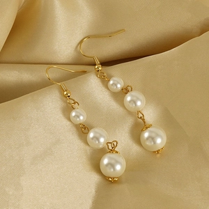 Boucles d'oreilles élégantes en acier doré 18 carats avec perles sur tissu de soie champagne
