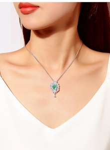 Close-up of S925 sterling silver necklace with green gemstone and sparkling diamond accents