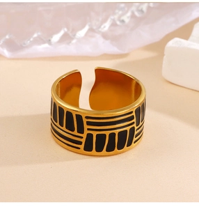 Detail of adjustable gold ring with black geometric patterns and vintage oil drip finish