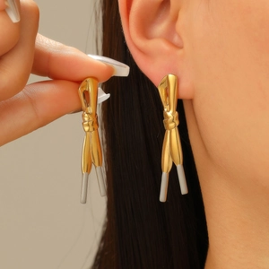 Gros plan de boucles d'oreilles en acier doré avec motif de nœud et d'aglet