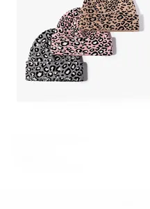 Dettaglio ravvicinato di berretti in maglia spessa con stampa leopardata in grigio e rosa