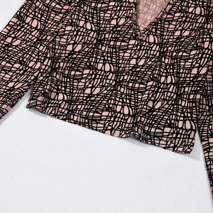 Close-up of pink and black abstract grid print on V-neck long sleeve crop top set