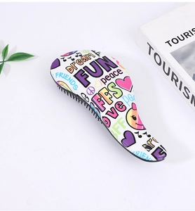 Close-up of a white hairbrush featuring colorful graffiti words and black bristles