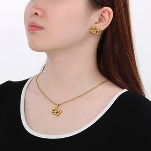 Model wearing 18K gold plated double heart necklace and matching stud earrings set