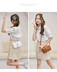 Detail of white and brown mini crossbody bags featuring crown locks and tassel decor